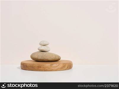 Stack of round stones on a white background. Scene for demonstration of cosmetic products, advertising
