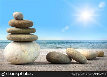 Stack of spa rocks on wood against blue sky