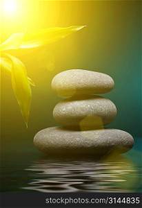 Stack of spa stones over color background with yellow light