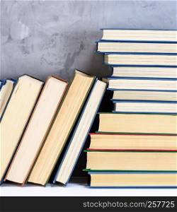 stack of various books on the table, gray background