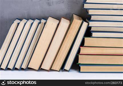 stack of various books on the table, gray background