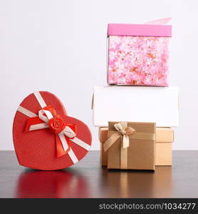 stack of various cardboard boxes for gifts on a black table, white background