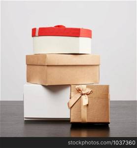 stack of various cardboard boxes for gifts on a black table, white background