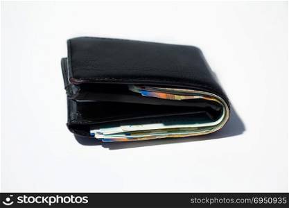 Stack of various of israeli shekel money bills in close black leather wallet.