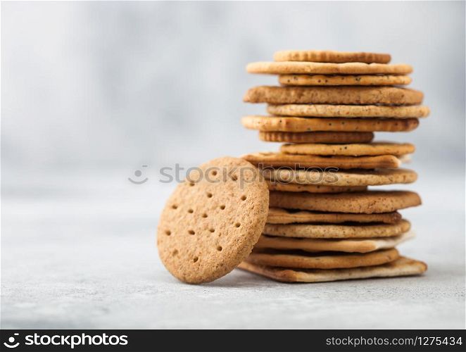 Stack of various organic crispy wheat, rye and corn flatbread crackers with sesame and salt on light background. Space for text