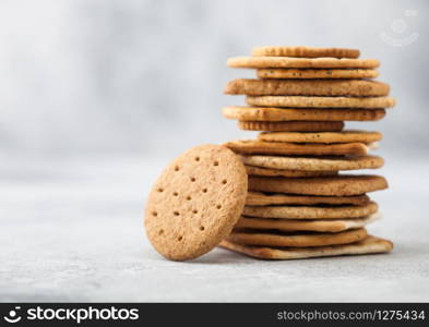 Stack of various organic crispy wheat, rye and corn flatbread crackers with sesame and salt on light background. Space for text