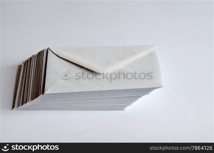 Stack of white envelopes shifted to right on white background.