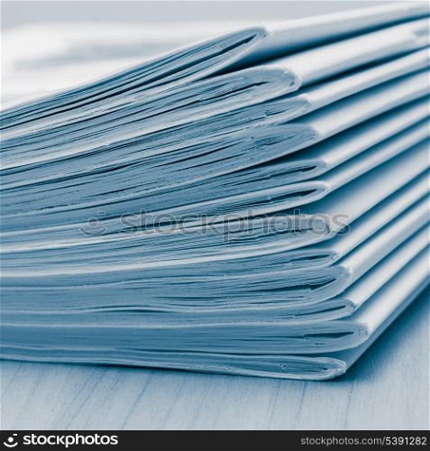 Stack of white journals on table, closeup blue toned
