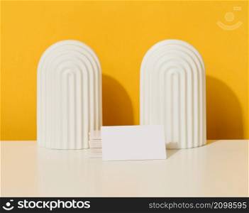 stack of white rectangular business cards on a yellow background, company branding, address.