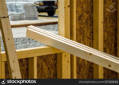 stack of wood stud planks at construction site resting on window opening