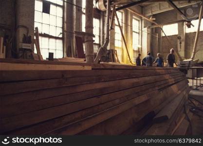 Stack of wooden blanks at the sawmill. Workers on background.. at the sawmill