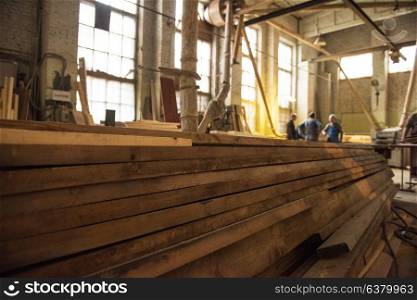Stack of wooden blanks at the sawmill. Workers on background.. at the sawmill