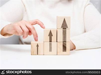 Stack of wooden cubes, the person’s fingers go up the steps. Business growth concept, goal achievement, self-education, career success