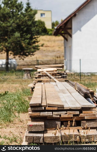 Stack of wooden piles plank boards on construction site. Renovation, building equipment concept.. Stack of wooden piles plank boards