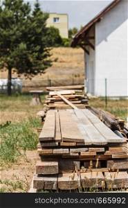 Stack of wooden piles plank boards on construction site. Renovation, building equipment concept.. Stack of wooden piles plank boards