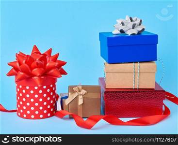 stack of wrapped gifts with knotted bows on a blue background, festive backdrop