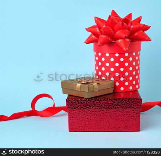 stack of wrapped gifts with knotted bows on a blue background, festive backdrop