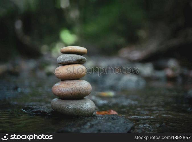 Stack of zen stones, Close up of pebble rocks stacked on top of each other in stream leading to a waterfall in a forest, Zen like concepts