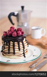 Stack pancakes with chocolate and raspberries