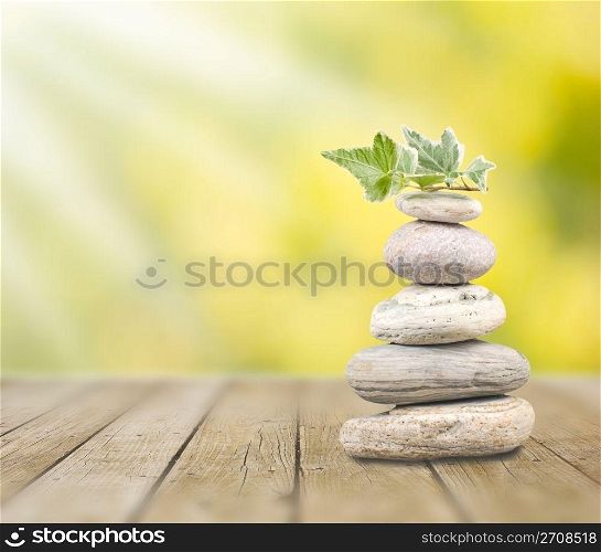 Stack pebbles on wooden table under sunshine