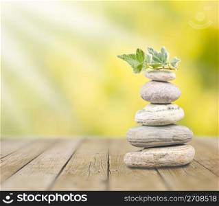 Stack pebbles on wooden table under sunshine