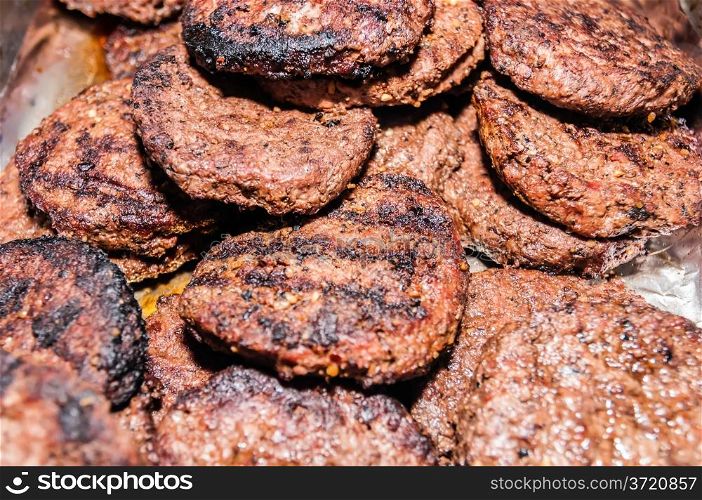 stack pile of cooked burgers on tray
