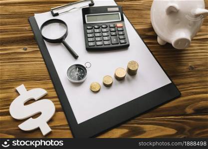 stacked coins compass magnifying glass calculator clipboard with dollar sign piggybank. Resolution and high quality beautiful photo. stacked coins compass magnifying glass calculator clipboard with dollar sign piggybank. High quality and resolution beautiful photo concept