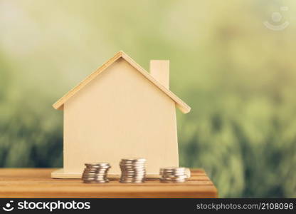 stacked coins near wooden house table outdoors