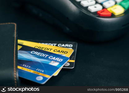 Stacked credit cards on table with Credit card reader machine or Payment terminal