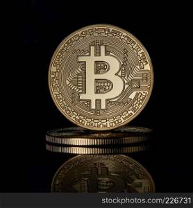 Stacked golden Bitcoin Cryptocurrency BTC Currency Technology Business Internet Concept on a black reflective surface background. Stacked golden bitcoins coins for BTC cryptocurrency on a black reflective surface background