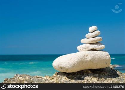 stacked limestone pebbles on the beach, blurred background. stacked pebbles on the beach