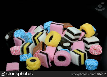 Stacked liquorice all sorts in different shapes, colors and sizes