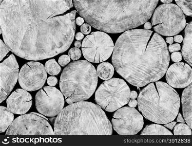 Stacked logs, wooden background, black and white photo