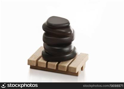 Stacked massage stones on wooden base