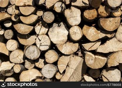 Stacked oak firewood in countryside as background