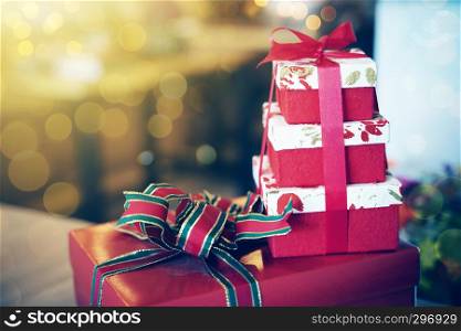 Stacked of gift boxes on table with blurred light background. Holiday and celebration concept.