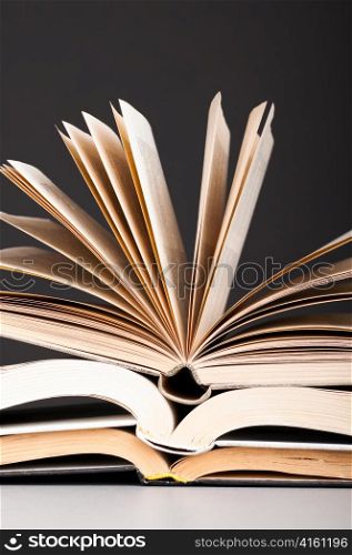 stacked open books on dark gray background
