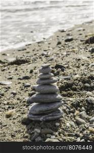 Stacked sea stones. Sea on the background. Contra light