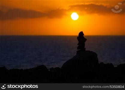 Stacked stones for a wish on Mediterranean sunset at Balearic islands