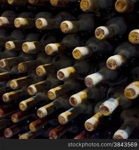 stacked up wine bottles in the cellar. old bottles of in wine cellar