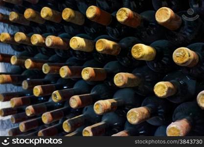 stacked up wine bottles in the cellar. old bottles of in wine cellar