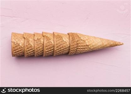 stacked waffle cones pink background