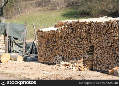 Stacked woodpile, photo taken on a sunny day in spring