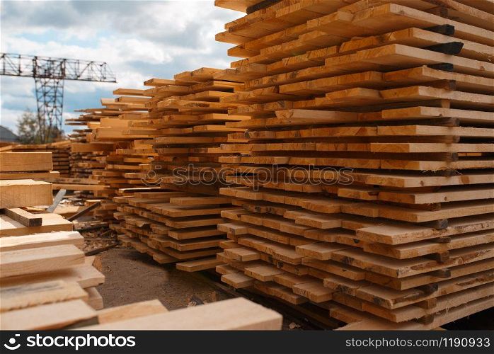 Stacks of boards on timber mill warehouse outdoor, nobody, lumber industry, carpentry. Wood processing on factory, forest sawing in lumberyard, sawmill