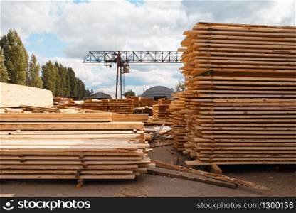 Stacks of boards on timber mill warehouse outdoor, nobody, lumber industry, carpentry. Wood processing on factory, forest sawing in lumberyard, sawmill. Stacks of boards on timber mill warehouse