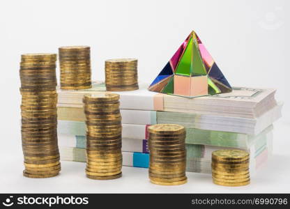 Stacks of coins, bundles of notes and a glass pyramid