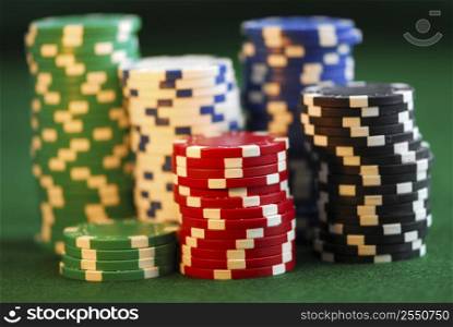 Stacks of gambling chips on green background