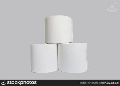 Stacks of rolls of toilet paper on white background