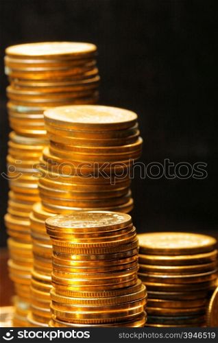 Stacks of the gold coins close up over black background