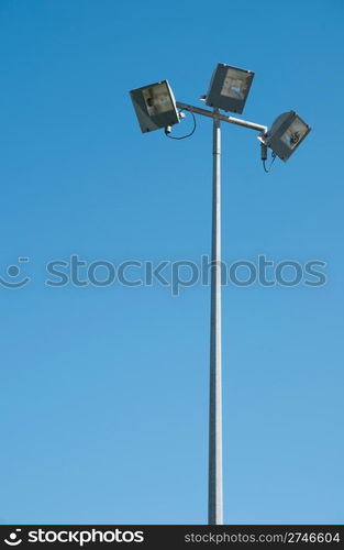 stadium lights pole against blue sky background